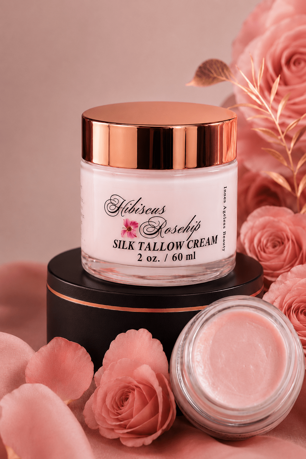 Hibiscus Rosehip Silk Tallow Cream 2oz jar with rose gold lid surrounded by pink roses by Innes Ageless Beauty