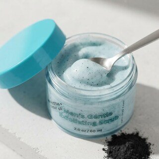 Macro close-up showing the light blue texture and fine exfoliating particles of the men's face scrub