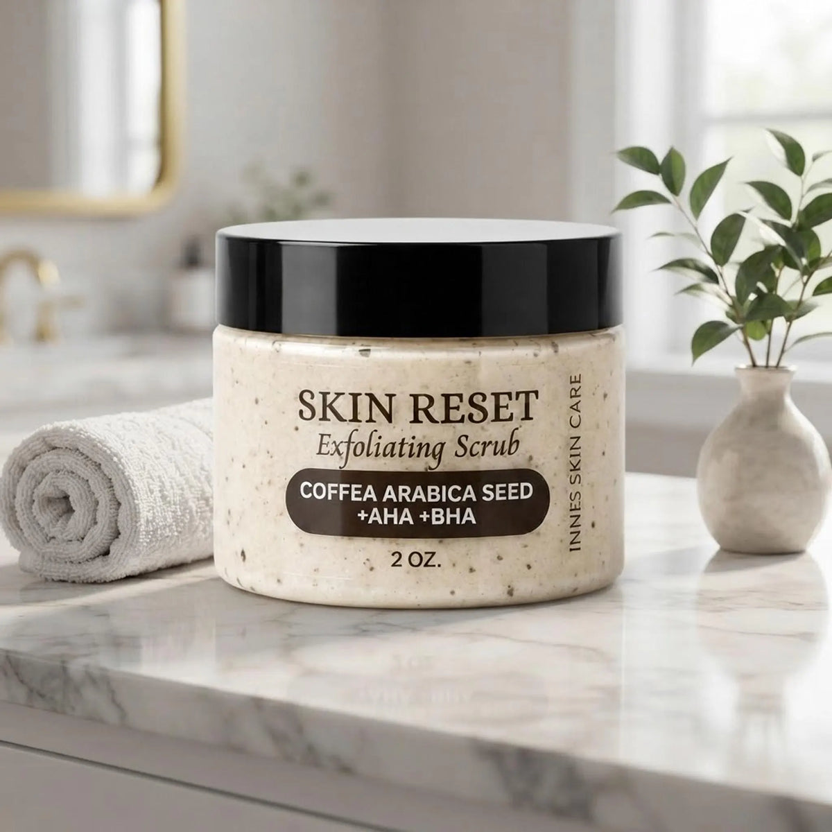 Coffee exfoliating face scrub jar on a marble bathroom counter with towel and greenery