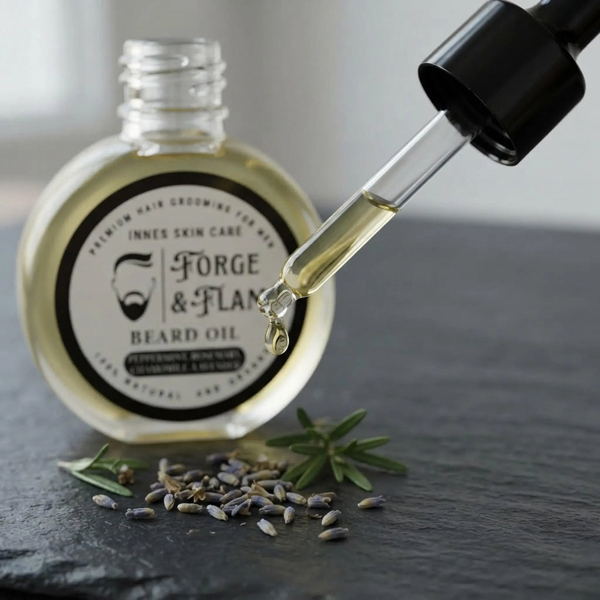 Macro shot of Forge and Flame beard oil dropper with a drop of oil and botanical herbs.