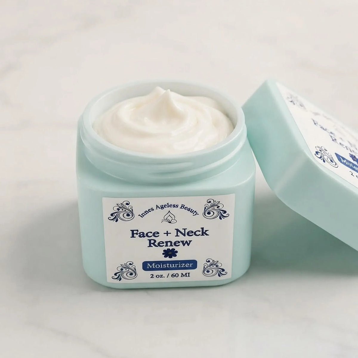 Open mint green jar of Face and Neck Renew Moisturizer revealing its smooth white cream texture.