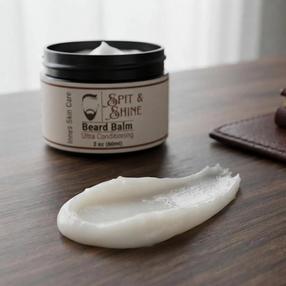 Close-up of the open jar of Spit & Shine beard balm showing its smooth, creamy white texture.