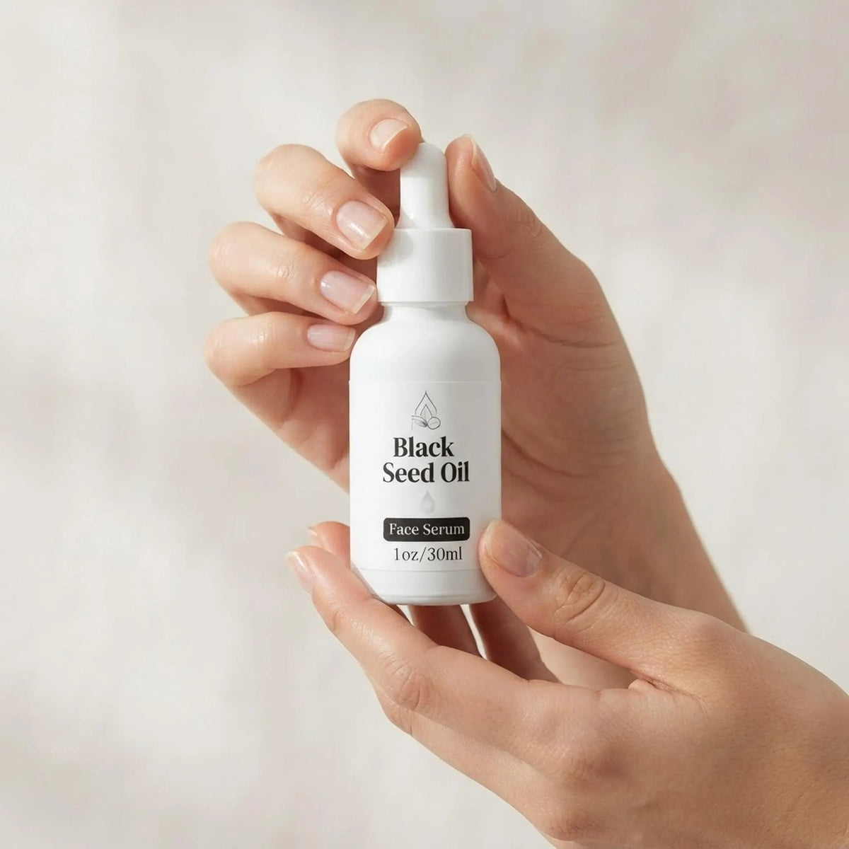 Hands holding the Black Seed Oil Face Serum bottle to show true product scale.
