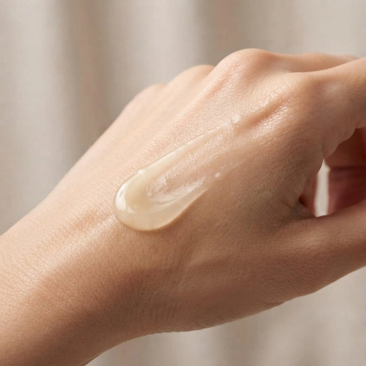 Close-up of Elite Glow Boost Vitamin C Serum being absorbed into skin showing lightweight texture.