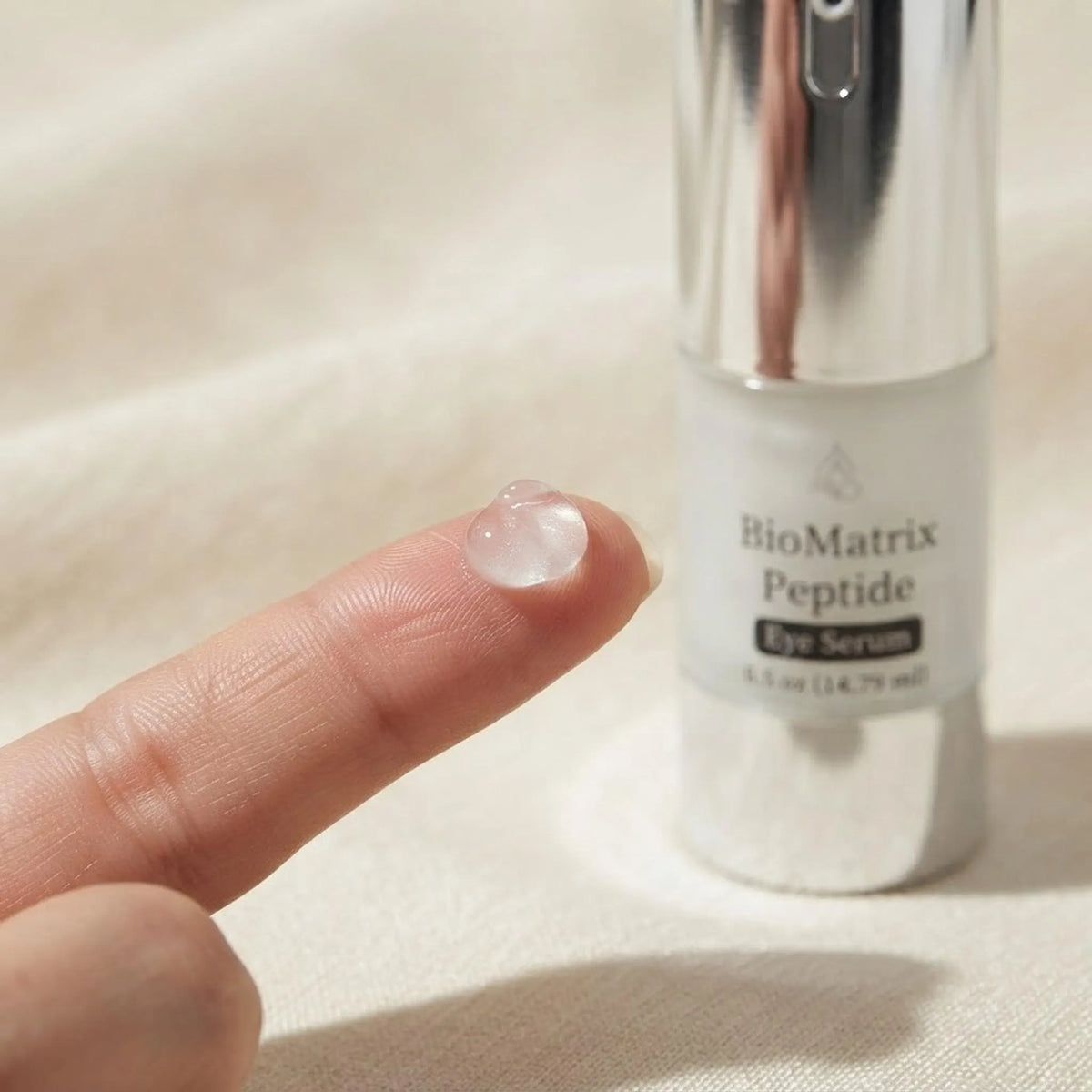 Macro shot of lightweight BioMatrix Peptide Eye Serum texture on a fingertip.
