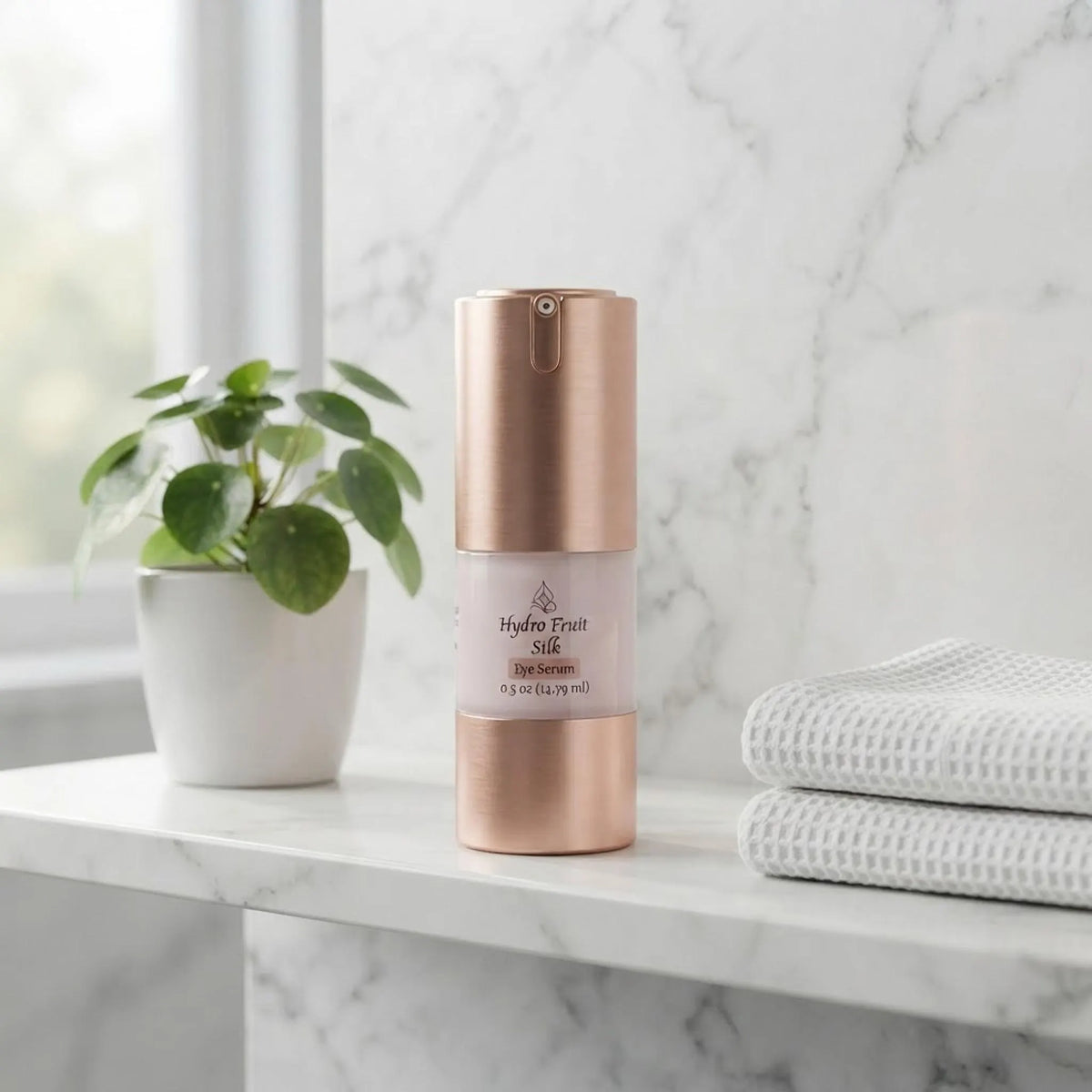 Hydro Fruit Silk Eye Serum on a marble bathroom shelf with a plant and towel.