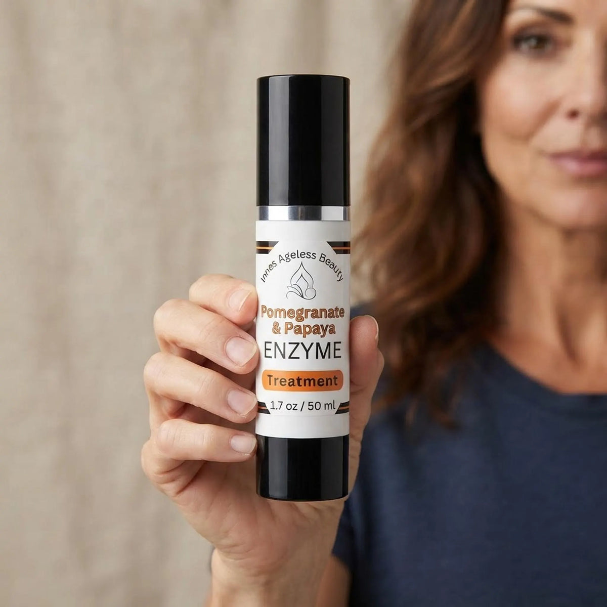 Person holding the 1.7 oz Pomegranate and Papaya Enzyme Treatment bottle to demonstrate product scale