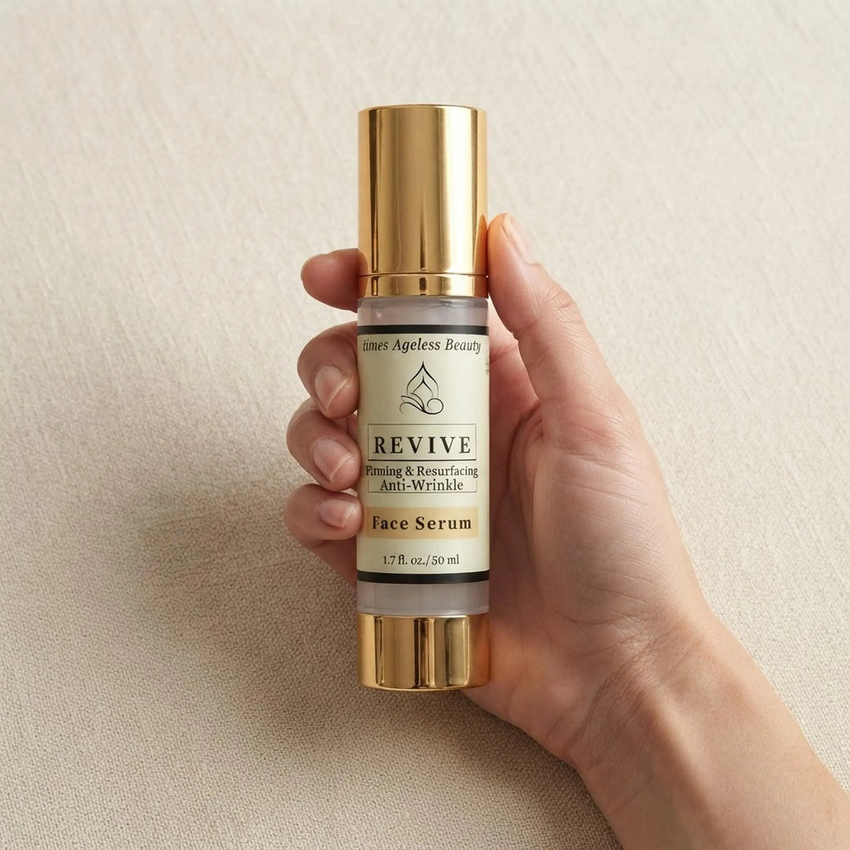 A hand holding the 1.7 oz Revive Face Serum bottle to demonstrate scale and bottle size.