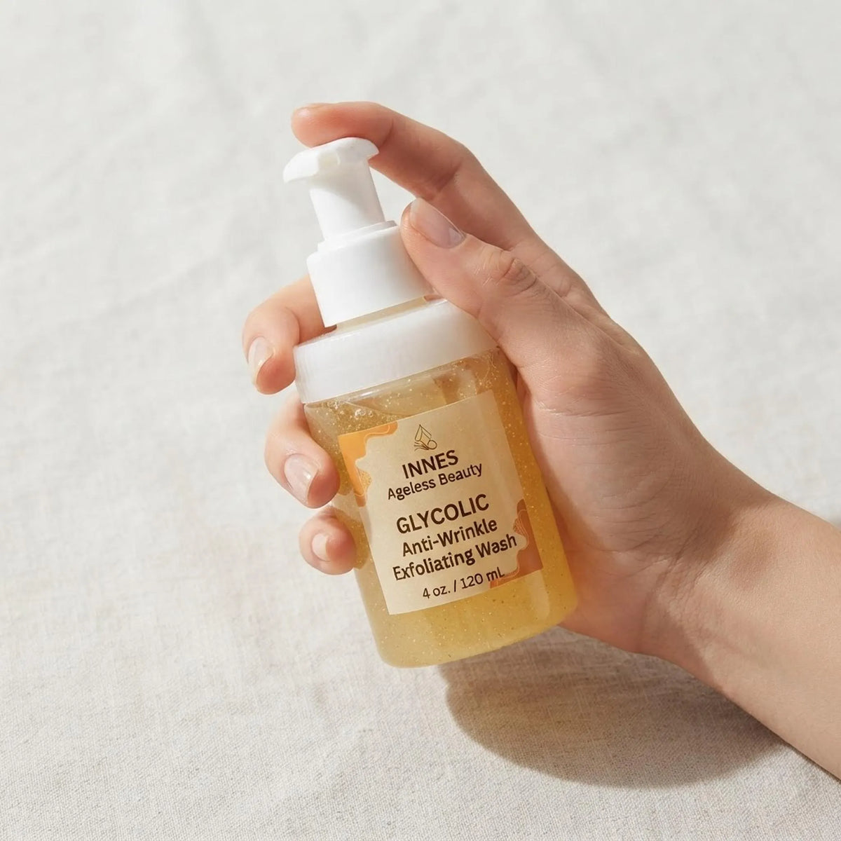 A person holding the 4oz Glycolic Anti-Wrinkle Exfoliating Wash bottle to show product scale.