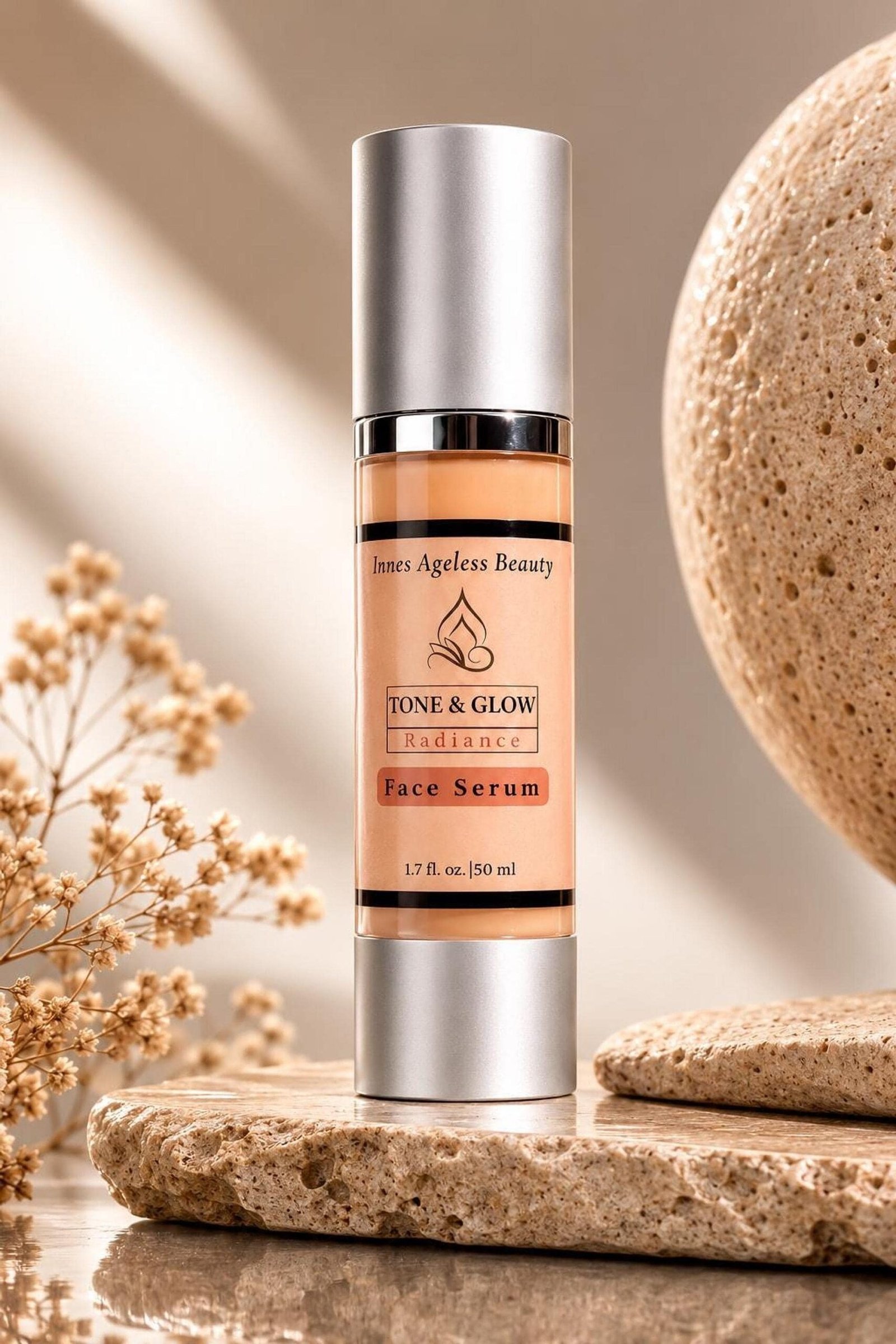 Tone and Glow Radiance Face Serum 1.7oz airless pump bottle on stone display with dried flowers by Innes Ageless Beauty
